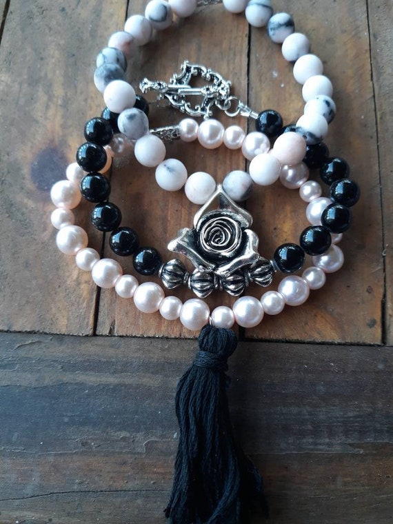 Set of three stackable bracelets with pearls in pink and black marble, black and pink glass, silver tone charm, toggle and black tassel