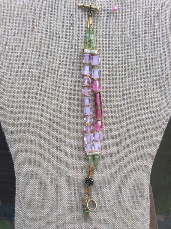Stunning pink lamp worked glass bracelet with green  peridot chips, gold plated, toggle closure.