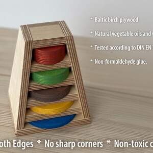 May include: A wooden stacking toy with five colorful rings. The toy is made of Baltic birch plywood and finished with natural vegetable oils and waxes. The toy is tested according to DIN EN 71-3 and is non-formaldehyde glue. The toy has smooth edges and no sharp corners. The colors are non-toxic.