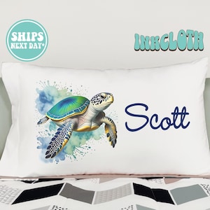 May include: White pillowcase with a watercolor illustration of a sea turtle with blue, green, and yellow accents. The name "Scott" is written in blue cursive lettering.