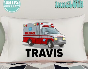 May include: White pillowcase with a cartoon ambulance and the name Travis printed in black.