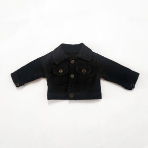 May include: A black corduroy jacket with a collared neckline, two flap pockets, and button closures.