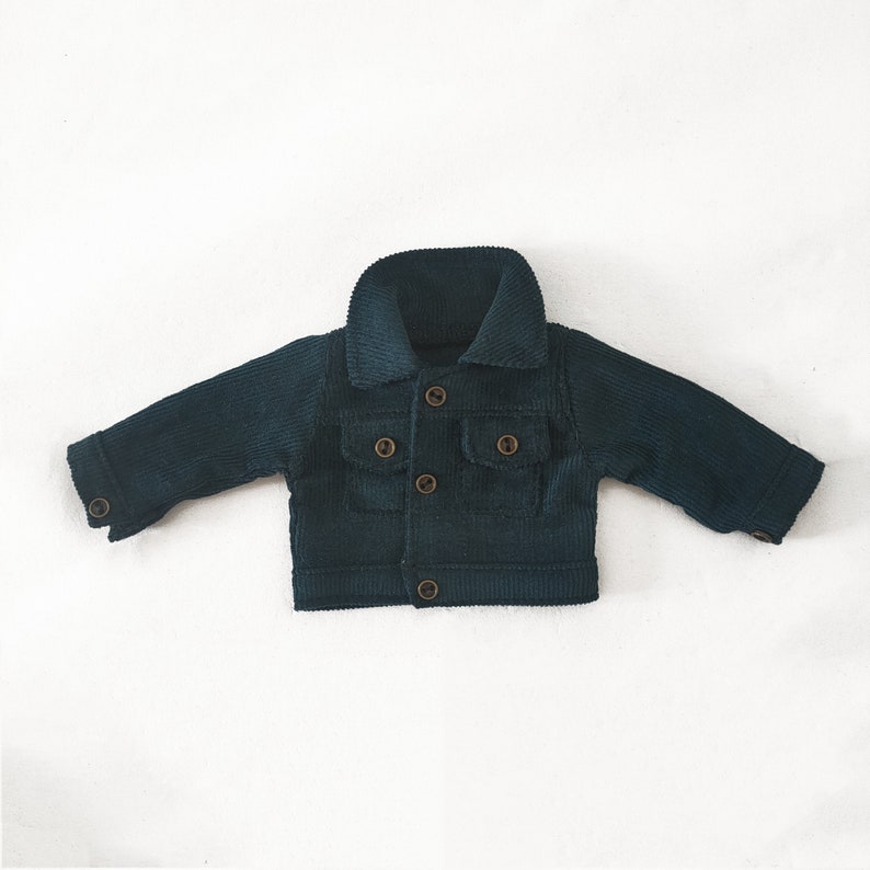 May include: A dark green corduroy jacket with a button closure and two front pockets.