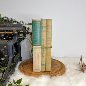Beige and green set of three vintage and antique books for decor purposes