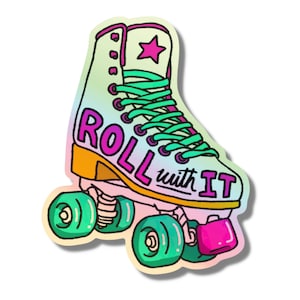 Puede incluir: Un patín de ruedas de colores con un diseño degradado de arcoíris y el texto "ROLL with IT" en letras rosa y negras. El patín tiene ruedas verdes y un tope de puntera rosa.