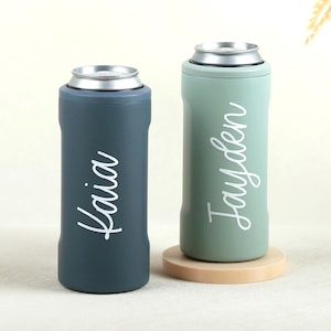 May include: Two cylindrical metal can coolers with silver rims. The left cooler is dark blue with the white script name Kaia. The right cooler is sage green with the white script name Jayden. Both feature a smooth matte finish and a slim design.