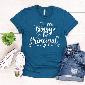 May include: Teal blue t-shirt with white text that reads "I'm not Bossy I'm the Principal!"