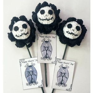May include: Three black and white crocheted flowers with a Jack Skellington face. Each flower has a black stem and a small card attached to the stem that says "Happy Hearts' Day!"