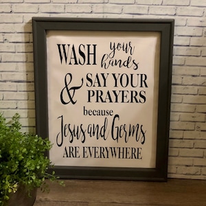 May include: A framed sign with a white background and black text that reads "Wash your hands & say your prayers because Jesus and germs are everywhere".