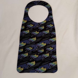 May include: A black doorstop with a repeating pattern of the Tampa Bay Rays logo. The logo is in blue, green, and yellow with the words "Tampa Bay Rays" and "Devil Rays".