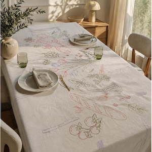 May include: A cream-colored tablecloth featuring embroidered line art of a lobster, tulips, a baguette, tomatoes, and various herbs. The design includes the word "Food" in cursive script, alongside outlines of cutlery, creating a detailed culinary-themed pattern.