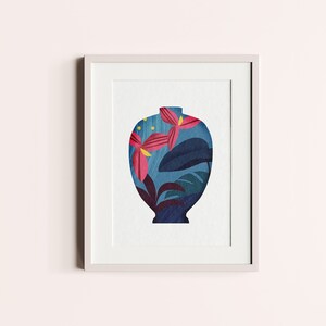 May include: A framed print of a blue vase with a floral pattern. The vase is filled with pink and yellow flowers and green leaves.