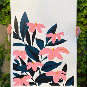 Könnte beinhalten: Ein weißer Hintergrund mit einem großen rosa und orangefarbenen Blumendruck. Die Blumen sind stilisiert und haben einen kühnen, grafischen Look. Die Blätter sind dunkelblau und grün.