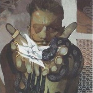 Può includere: Un uomo con la pelle scura e i capelli scuri indossa una camicia scura con un ciondolo d'argento. Tiene un oggetto bianco nella mano sinistra e un serpente nero nella mano destra.