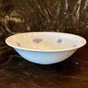 Może przedstawiać: Biała ceramiczna miska z jasnoniebieskim wzorem kwiatowym. Miska jest okrągła i ma lekko rozszerzający się brzeg.