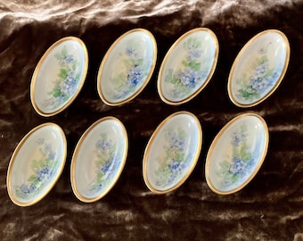 Set of 8 hand-painted Austrian porcelain salt cellars with gilded borders