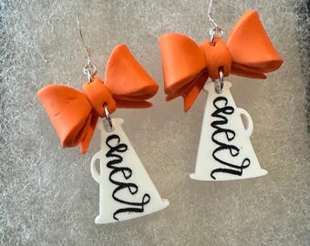 Pendientes de megáfono de porristas del día del juego unidos a un lazo de arcilla naranja