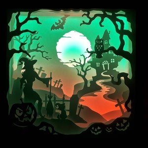 K&ouml;nnte beinhalten: Ein geschichtetes Papierkunstwerk, das eine Halloween-Szene darstellt. Silhouetten einer Hexe, eines Spukhauses, einer Eule und K&uuml;rbissen sind vor einem gr&uuml;n-orangen Farbverlaufshintergrund angeordnet. Ein Vollmond und unheimliche B&auml;ume vervollst&auml;ndigen das Design.