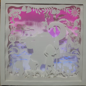 May include: A white, layered paper art piece depicting a tropical scene with a pink and purple gradient background. The artwork features silhouettes of characters, plants, and a boat, all within a white frame. The scene is illuminated with blue and pink lights.