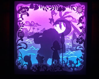 May include: A layered paper art piece featuring silhouettes of characters and tropical scenery. The artwork depicts a beach scene with a sailboat, palm trees, and figures, illuminated with purple and blue lighting. The piece is framed with decorative cutouts.