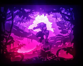 May include: A backlit art piece depicting a crouching figure in a jungle setting. The artwork uses shades of purple, pink, and black to create a dramatic scene. The figure is holding two spears, and the jungle foliage is silhouetted.