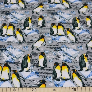 Könnte beinhalten: Ein grauer Stoff mit einem sich wiederholenden Muster aus Pinguinen und blauen geometrischen Formen. Die Pinguine sind schwarz und weiß mit gelben Schnäbeln und Füßen. Die geometrischen Formen ähneln Eiskristallen.