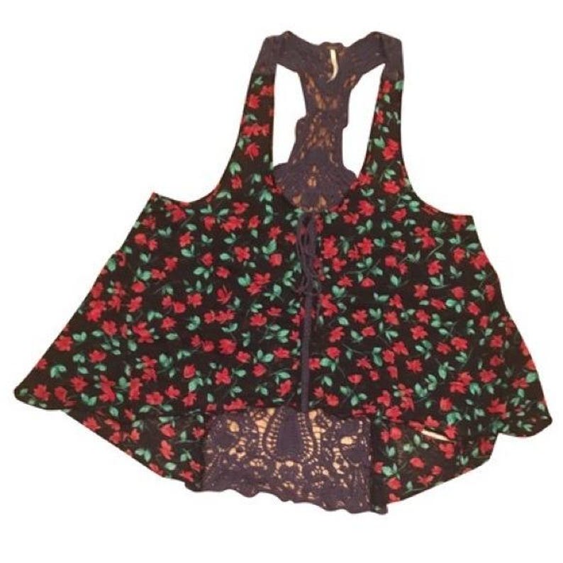 Puede incluir: Un top sin mangas negro con un estampado floral de rosas rojas y hojas verdes. El top presenta una parte delantera con cordones y una espalda de encaje azul marino. El dobladillo inferior tambi&eacute;n es de encaje azul marino.