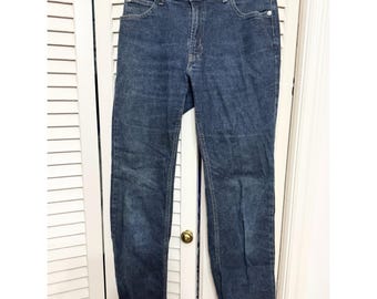 May include: Dark wash denim jeans with a classic five-pocket design. The jeans have a button and zipper closure, belt loops, and a straight leg fit. The brand name is visible on the waistband.