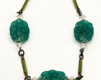 Peut inclure: Un bracelet en jade vert avec trois perles de jade sculptées et des perles de cristal claires. Le bracelet est composé d'une chaîne dorée avec des accents d'émail vert.