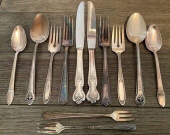 Puede incluir: Un juego de cubiertos vintage, que incluye un cuchillo, tenedores y cucharas. Los cubiertos están hechos de plata y tienen un diseño decorativo. Los cubiertos están en buen estado y serían una gran adición a cualquier cocina.