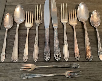 May include: A set of vintage silverware, including spoons, forks, and a butter knife. The silverware is made of silver and has an ornate design. The silverware is in good condition and would be a great addition to any kitchen.