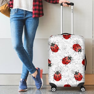 May include: White luggage cover with a pattern of red ladybugs and black outlines of flowers.