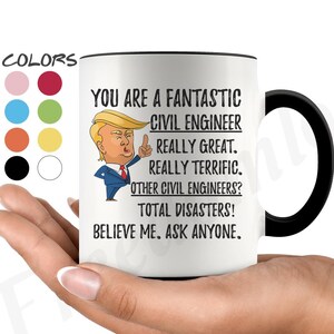 May include: White ceramic coffee mug with a black handle. The mug has a black rim and features a cartoon image of a man with a red tie and a black suit. The text on the mug reads "You are a fantastic civil engineer. Really great. Really terrific. Other civil engineers? Total disasters! Believe me. Ask anyone."