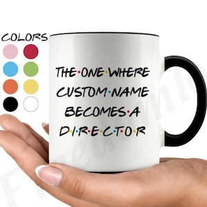 May include: White ceramic mug with a black handle. The mug has black text that reads "THE ONE WHERE CUSTOM-NAME BECOMES A DIRECTOR" with a black dot between each word.