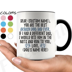 Puede incluir: Taza de café de cerámica blanca con borde y asa negros. La taza tiene un mensaje que dice "Querido (Nombre personalizado), Eres el mejor papá de perro Akbash de todos los tiempos. Si tuviera un padre diferente, le mordería las nueces y correría hacia ti. Amor, (Nombre del perro aquí)"