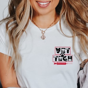 Op de afbeelding: Een wit T-shirt met de tekst "VET TECH" in een rode box. De tekst wordt omringd door zwarte silhouetten van dieren en een spuit.