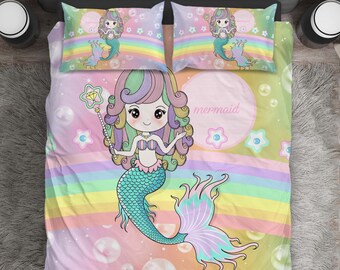 Könnte beinhalten: Ein rosafarbenes, gelbes und blaues Meerjungfrauen-Bettwäsche-Set mit einem Regenbogen und Blasen. Das Set zeigt eine Comic-Meerjungfrau mit langen, bunten Haaren und einem Sternenstab. Der Text "mermaid" ist auf der Bettwäsche geschrieben.