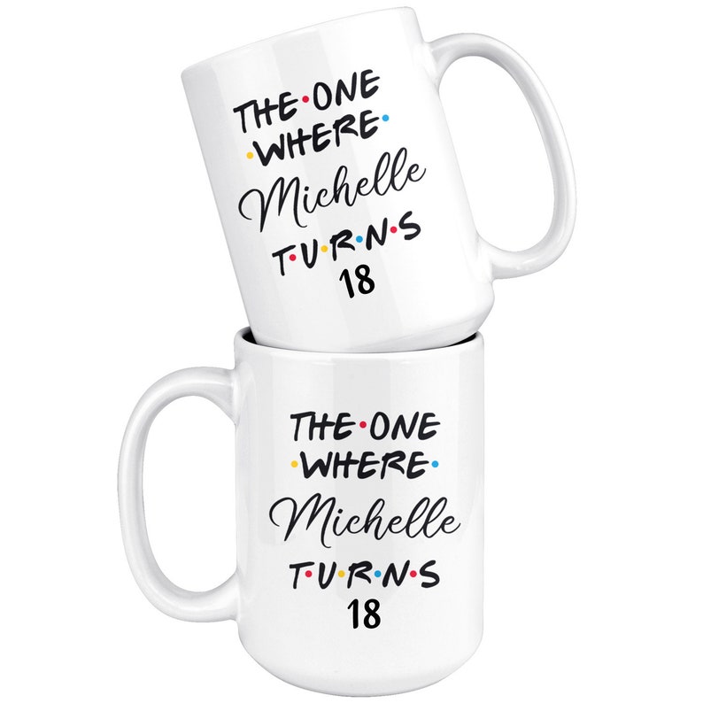 May include: Two white coffee mugs stacked on top of each other. The mug on top has the text "THE ONE WHERE Michelle TURNS 18" in black with colorful dots. The mug on the bottom has the same text.