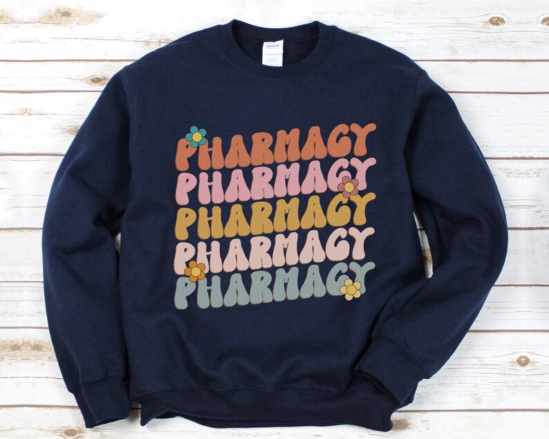 May include: Navy blue sweatshirt with the word "Pharmacy" repeated five times in a retro font with colorful flowers.
