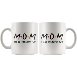 May include: Two white ceramic mugs with black text that reads "M.O.M. I'll be there for you".