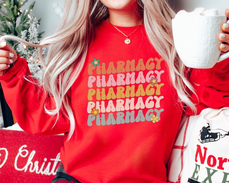 May include: Red sweatshirt with the word "Pharmacy" repeated five times in a rainbow of colors with a flower design next to each word.
