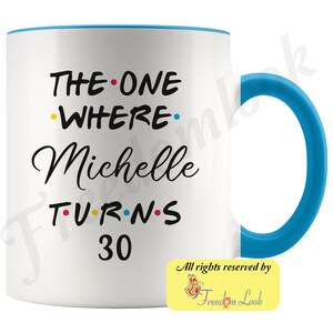 May include: White ceramic mug with a blue rim and handle. The mug features black text that reads "THE ONE WHERE Michelle TURNS 30" with colorful dots between the words. The text "All rights reserved by Freedom Look" is printed in yellow on a white butterfly graphic in the bottom right corner.