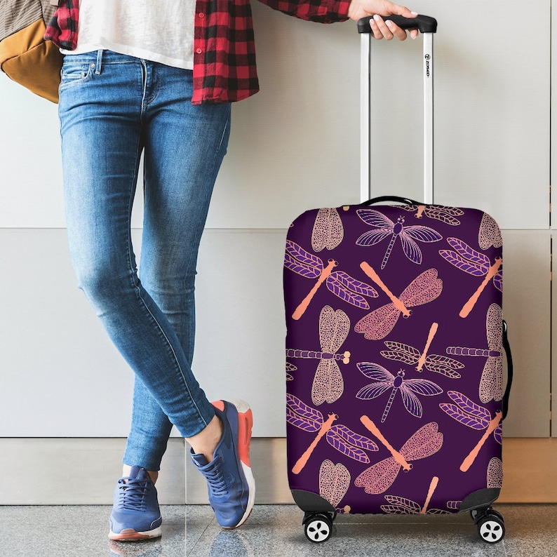May include: Purple suitcase cover with a pattern of pink and orange dragonflies.