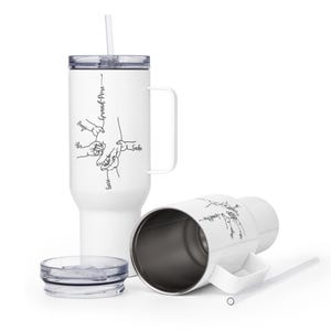 May include: White insulated tumbler with a handle, straw, and lid. The tumbler features a black line drawing of hands holding each other, with the word "Grand-Pere" and names. One tumbler is upright, and another is lying on its side.