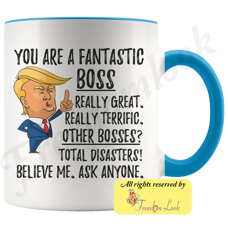 May include: White ceramic coffee mug with a blue rim and handle. The mug features a cartoon image of Donald Trump with the text "You are a fantastic boss. Really great. Really terrific. Other bosses? Total disasters! Believe me. Ask anyone."