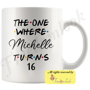 K&ouml;nnte beinhalten: Wei&szlig;e Keramiktasse mit schwarzem Text, der "The One Where Michelle Turns 16" lautet. Der Text hat farbige Punkte zwischen den W&ouml;rtern. Die Tasse hat einen schwarzen Henkel.