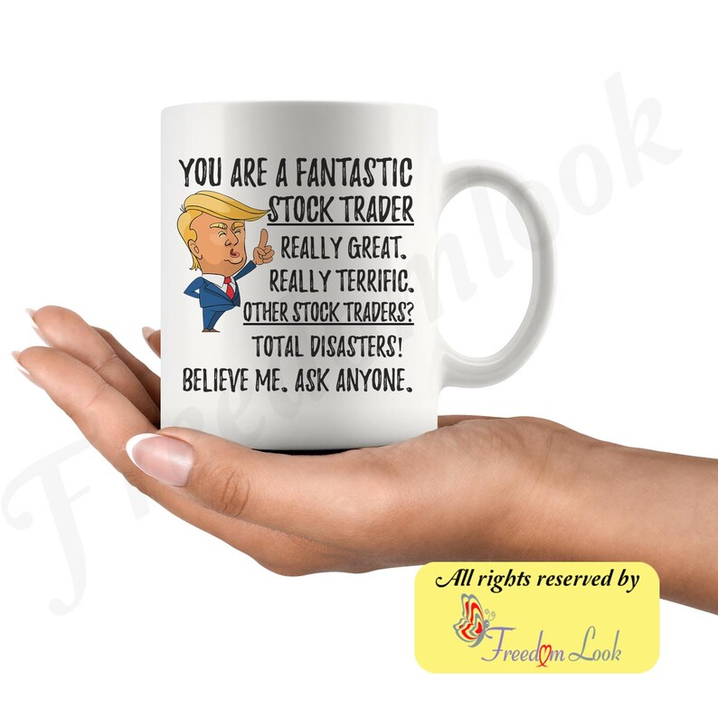 Op de afbeelding: Een witte keramische mok met een zwart-witte illustratie van een cartoonfiguur met blond haar. De tekst op de mok luidt "You are a fantastic stock trader. Really great. Really terrific. Other stock traders? Total disasters! Believe me. Ask anyone."