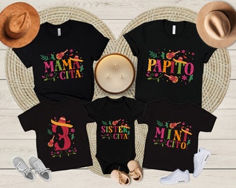 May include: A set of four black t-shirts with colorful Mexican-themed designs. The shirts feature the text "Mama Cita", "Papito", "Sister Cita", and "Mini Cito".