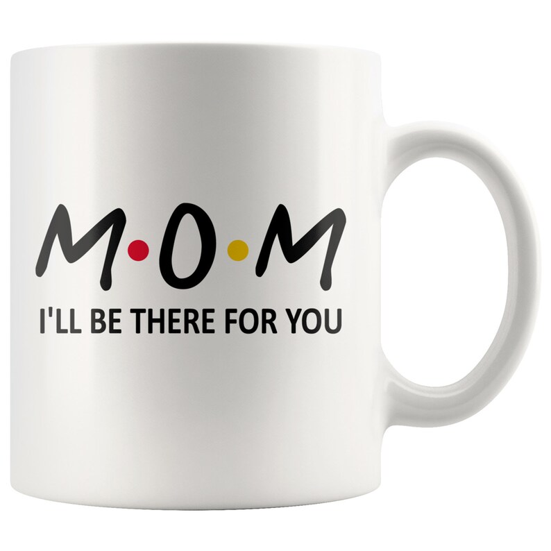 May include: White ceramic coffee mug with black text that reads "M.O.M. I'll be there for you".