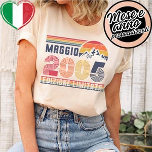 以下が含まれることがあります： レトロなデザインのクリーム色のTシャツ。「MAGGIO」の文字がカラフルなストライプフォントで「2005」の上に配置されています。「EDIZIONE LIMITATA」の文字が下にあります。右側には「Mese e anno personalizzati」の文字が入った円形のグラフィックがあります。